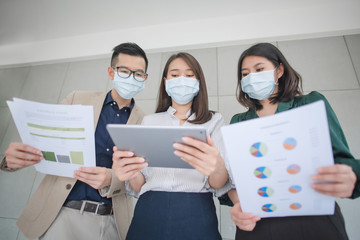 Business employee wearing face mask during work in office to keep hygiene follow company policy prevent epidemic from coronavirus or covid19