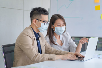 Business employee wearing face mask during work in office to keep hygiene follow company policy prevent epidemic from coronavirus or covid19.