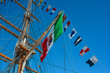 Italian flag with another flags on the mast