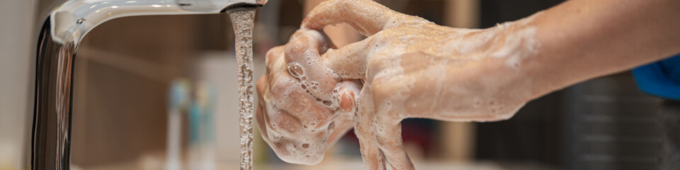 Wide closeup view of a woman washing her hands