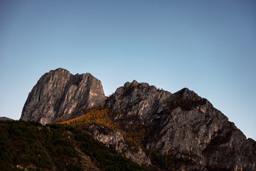 Limestone rock mountain with autumn pine forest and blue sky