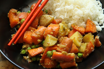 Carrots and Potatoes in a Bowl with Basmati Rice and Chopsticks Asian Food Close Up