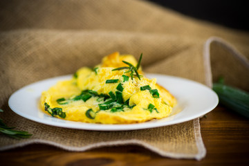 hot fried omelet with chopped green onions in a plate