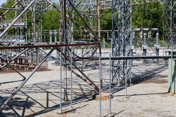 An array of ground supports, trusses, and insulators at an electrical power substation, horizontal aspect