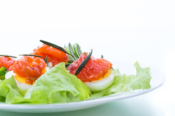 boiled eggs with salted red fish and salad leaves