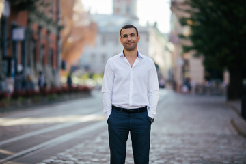 Obraz premium young man in shirt and glasses standing on city street