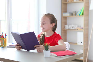 Fototapeta na wymiar little girl reads a book at home 