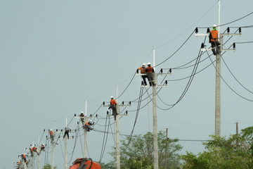 Electrician worker climbing electric power pole to repair the damaged power cable line problems...