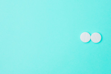 White pills on a blue background with copyspace.