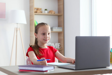 A child learns online at home through a modern laptop on the Internet.
