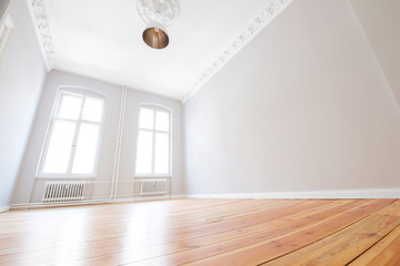 empty apartment room with wooden floor after renovation in beautiful old building