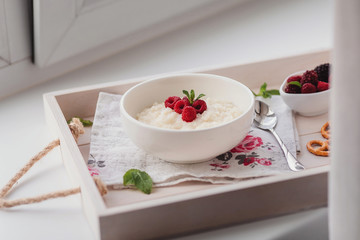 Rice porrige and berries  on a tray