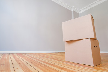 cardboard box in empty room, moving in new flat