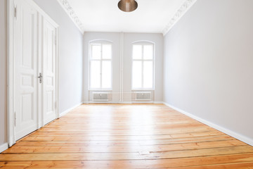 empty apartment room with wooden floor after renovation