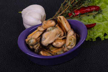 Pickled mussels in the bowl served pepper, garlic and salad