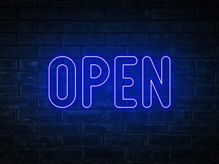 Open - blue neon light word on brick wall background	

