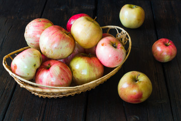 Apples in a basket and honey on a black background.