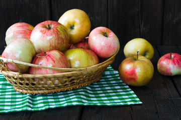 Apples in a basket and honey on a black background.