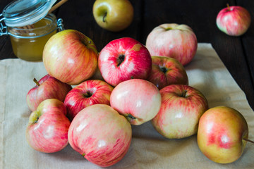 Apples in a basket and honey on a black background.
