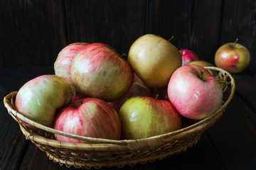 Apples in a basket and honey on a black background.
