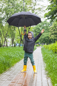 Boy in yellow boots in the rain