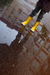 Boy in yellow boots in the rain