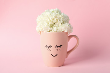 Cup with hydrangea flowers on pink background. Spring plant