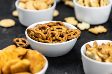 Mixed Snacks on dark background (close up shot; selective focus)