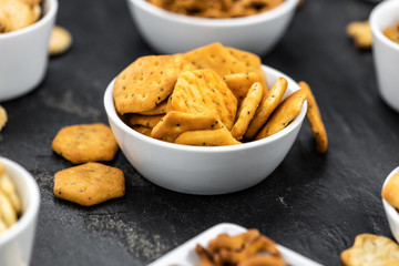 Mixed Snacks on dark background (close up shot; selective focus)