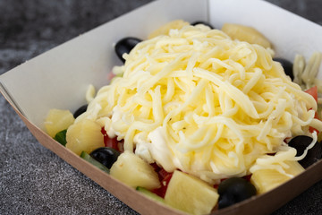 .salad of fresh vegetables from tomatoes, cucumbers, olives and pineapples. salad with mayonnaise and cheese