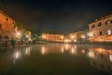 Fototapeta na wymiar Central square with the thermal pool in old town Bagno Vignoni at night. Tuscany, Italy