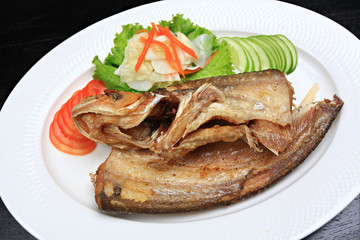 Fried garlic soft fish. Fried river fish with garlic and pepper background