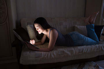 Fototapeta premium Girl working on a tablet in the dark at night