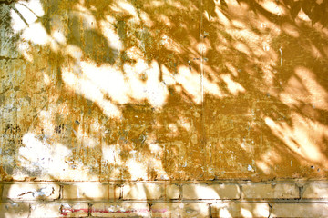 Yellow wall of the building in the light of day and shadows