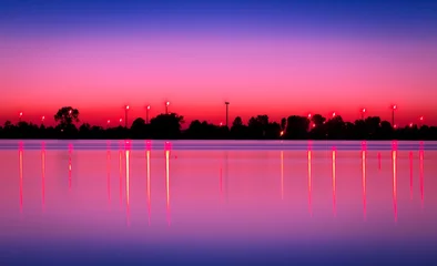 Foto op Plexiglas Roze Meer na zonsondergang met windmolens op de achtergrond