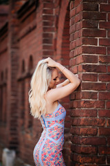 Beauty woman. Blonde woman posing on red building background