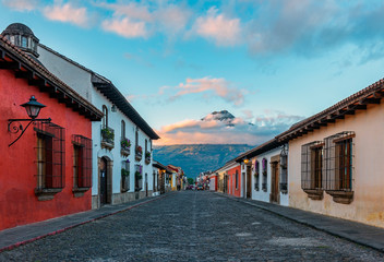 Fototapeta na wymiar Sunrise in a colonial style street of Antigua City with the Agua volcano in the background, Guatemala.