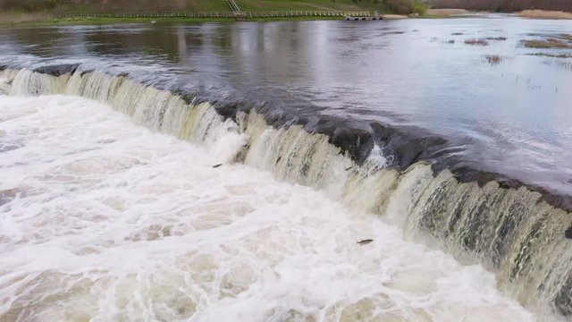 Epic jumping vimba fish at Venta Rapid waterfalls in slow motion aerial
