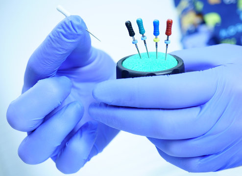 An endodontist physician places the endodontic instruments in a sterile box. A set of hand tools placed in a sterile box