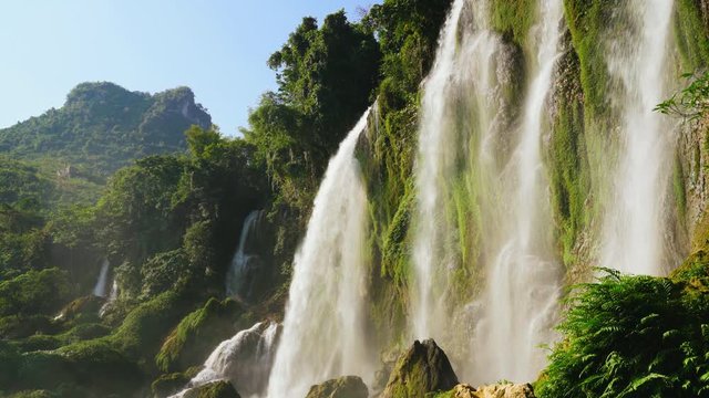 Majestic Waterfall in Summer with Green Forest and Mountains