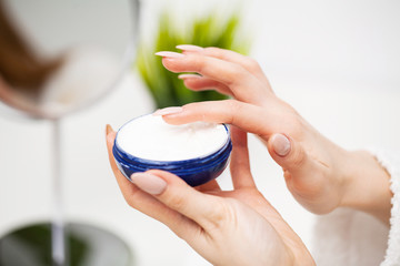 Woman close up holding moisturizer for skin care