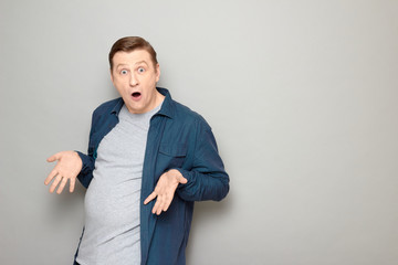 Portrait of man being surprised with his big stomach and fat body