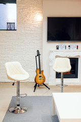 salon moderno con guitarra y asientos vacios