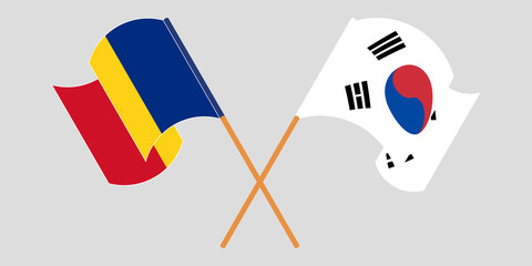 Crossed and waving flags of Romania and South Korea