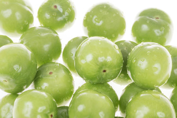 fresh green plums with drops isolated over white