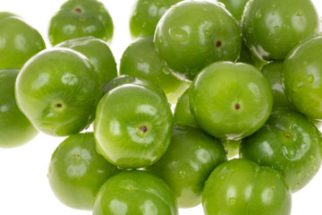 fresh green plums with drops isolated on white