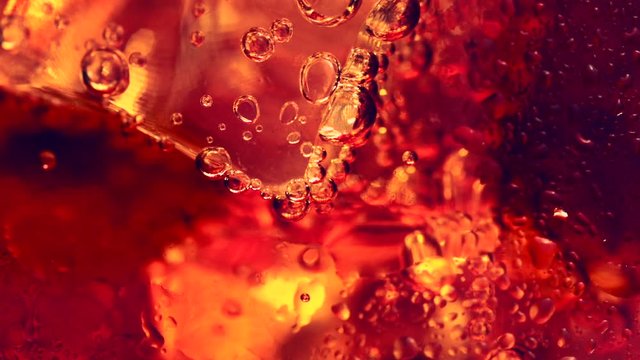 Cola with Ice and bubbles, macro shot. Abstract sweet food liquid background