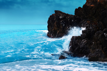 Huge ocean waves breaking on the coastal cliffs, cloudy stormy day. Storm season, seascape. Waves breaking on the rocks, coastline