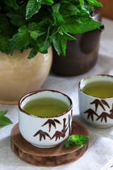 Mint tea in a vintage Chinese tea set, and a mint bouquet in a jug. Rustic style.