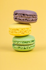 stack of colorful macaroons on yellow background